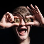homme avec 2 pieces de bitcoin en or sur les yeux - bonuscasinosansdepot.net